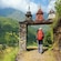 A person with a backpack walking under a stone arch, with the Norwegian mountains